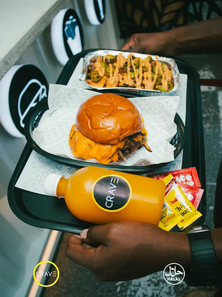 Crave tray with cheeseburger, loaded fries and fresh juice