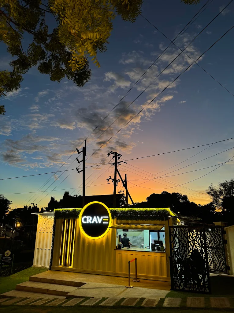 Crave storefront with glowing neon sign at dusk